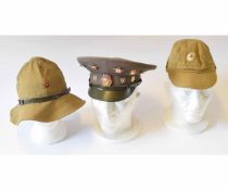 Mixed Lot: three various Soviet period hats including a peaked cap adorned with various Communist