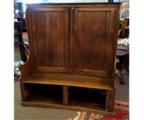 Late 18th/early 19th century settle of curved form with two panelled cupboard doors to back, with