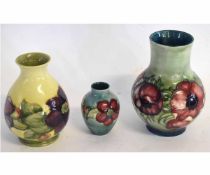 Group: three mid-20th century Moorcroft vases with tube lined anemone and hibiscus decoration on