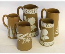 Collection of brown ground jugs, with applied floral decoration in white, all late 19th century,