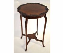 Edwardian mahogany circular carved top occasional table on four shaped legs, supported by an X
