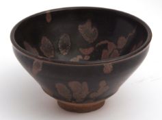 Japanese red clay tea bowl with a thick black Tenmoku iron glaze applied using a splashed wax resist