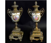 Pair of French gilt urns with painted porcelain panels of classical figures with a brass stepped