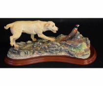 Porcelain model of a dog and a pheasant on a wooden base, 30cms long