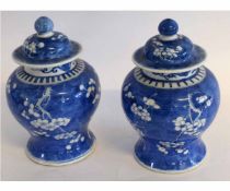 Pair of Chinese baluster vases and covers decorated with prunus on a blue ground, 28cms high