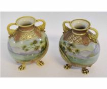 Pair of Noritake 20th century vases, standing on four paw feet, decorated with landscape scenes, the