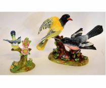 Two Crown Staffordshire models of birds sitting on tree stumps with flower encrusted bases by J T