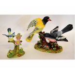 Two Crown Staffordshire models of birds sitting on tree stumps with flower encrusted bases by J T