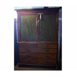 Regency style mahogany linen press, the upper doors with brass grilles enclosing fitted slides and