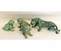 Oriental model of a tiger with black stripes on a celadon ground, together with three puppies with a