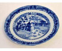 19th century blue and white printed plate decorated with an Oriental village scene, 22cms diam