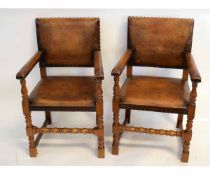 Pair of early 20th century oak framed leather upholstered open armchairs