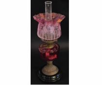 Victorian brass oil lamp with cranberry font and etched cranberry shade (a/f), raised on a