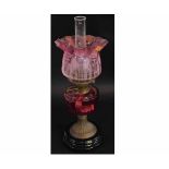 Victorian brass oil lamp with cranberry font and etched cranberry shade (a/f), raised on a
