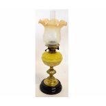 Victorian oil lamp with stepped and reeded brass column on a black slag base with a shaped yellow