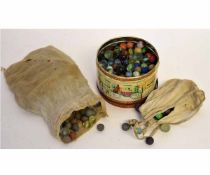 Tin and bag containing quantity of mixed marbles