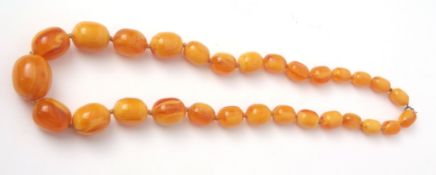 Amber type necklace, a single row of oval shaped graduated beads, 30mm to 12mm, egg yolk and