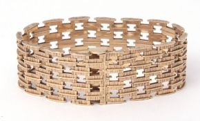 9ct gold cocktail bracelet, the wide articulated strap composed of textured brick shaped links in
