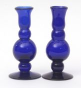 Pair of blue glass candlesticks of lobed baluster form terminating in spreading circular bases,