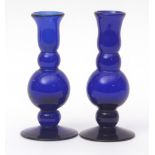 Pair of blue glass candlesticks of lobed baluster form terminating in spreading circular bases,