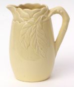 Large yellow ground Clarice Cliff jug with moulded floral design to the top, 28cms high