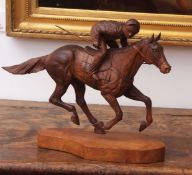 Ian Norbury carved walnut model of racehorse and jockey on a yew wood plinth, 44cms long