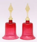 Two Victorian cranberry glass hand bells with tinted opaque handles, each 30cms high