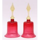 Two Victorian cranberry glass hand bells with tinted opaque handles, each 30cms high