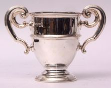 George V two-handled trophy cup, the polished and girdled body (erased) with applied flying C-scroll