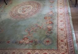 Large Indian or Chinese thick pile wool carpet, typically decorated on a pale blue green field,