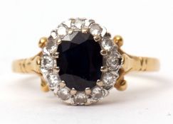 18ct gold sapphire and diamond ring, the dark oval faceted sapphire surrounded by twelve small