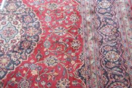 Kashan carpet, multi-gulled border, central lozenge, mainly red and blue field, 303cms x 205cms