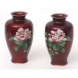 Pair of Japanese cloisonne and gin bari enamel vases with sprays of roses against a translucent ruby