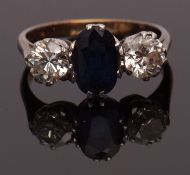 Sapphire and diamond three-stone ring, the oval shaped faceted sapphire set between two brilliant