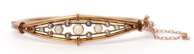 9ct gold opal and seed pearl hinged bracelet of openwork design, having a row of five small