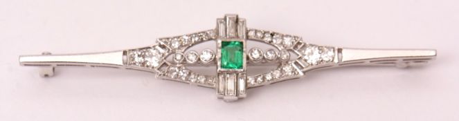 Precious metal Art Deco emerald and diamond brooch, the central rectangular emerald flanked either