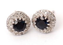 Pair of sapphire and diamond cluster earrings, the round faceted sapphires claw set to a surround of