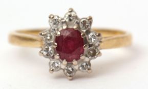 18ct gold ruby and diamond ring, the oval shaped faceted ruby claw set within a surround of ten