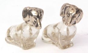 Two Continental white metal mounted moulded clear glass novelty pepper casters, each modelled in the
