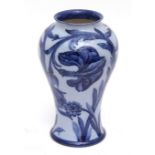 A rare early 20th century Moorcroft baluster vase with tube-lined and painted decoration of lilies