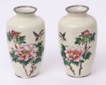 Pair of Japanese cloisonne vases with birds flying above sprays of peony against an ivory coloured