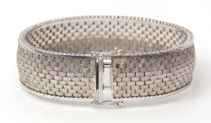 Precious metal articulated bracelet, a textured mesh work design, having angled bar borders, stamped
