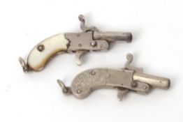 Mixed Lot: two various small novelty cap pistols, the first of all base metal construction with