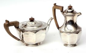 George V part tea set comprising tea pot and hot water pot, each of faceted circular form with