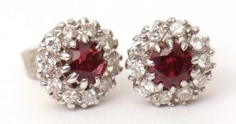 Pair of ruby and diamond cluster earrings, the round faceted rubies claw set to a surround of ten