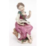 18th century Meissen figure of a young girl seated on a rocky base reading a musical score, 12 1/