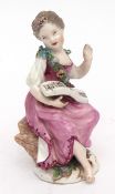 18th century Meissen figure of a young girl seated on a rocky base reading a musical score, 12 1/