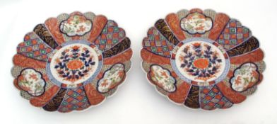 Pair of fluted and scalloped Japanese Imari chargers decorated with panels of exotic birds within