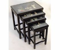 Set of four 20th century Oriental lacquered nesting tables with carved stone decoration to top