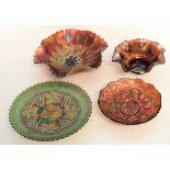 Group of four carnival glass dishes in iridescent orange, the largest 23cms diam